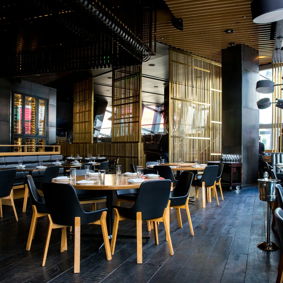 Een lege restaurantzaal met gedekte tafels.